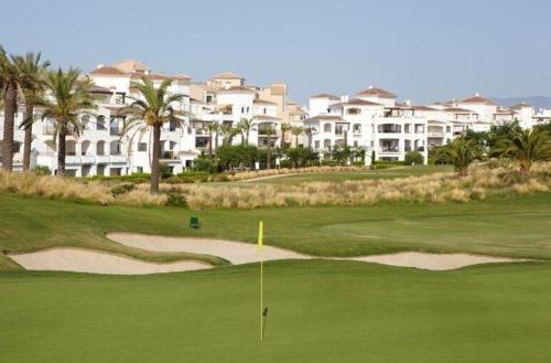 Blick auf einen Golfplatz mit Eigentumswohnungen im Hintergrund in der Unterkunft Villa Marrajo La Torre Golf Resort in Torre-Pacheco