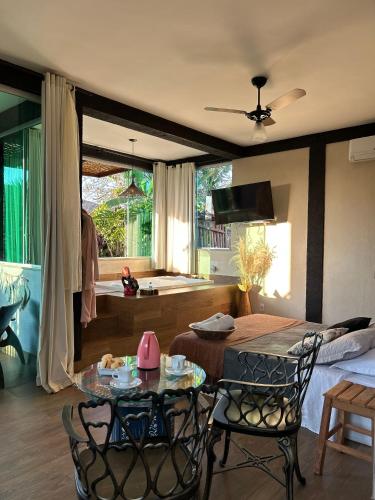 a living room with a table and chairs and a bedroom at Loft Mandalua in Serra do Cipo