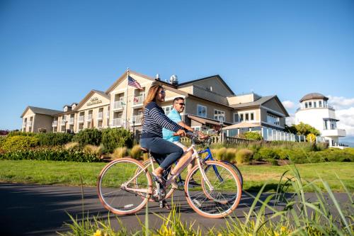 a woman riding a bike with a child on it at Hotel Bellwether on Bellingham Bay in Bellingham