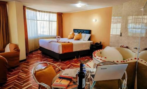 アレキパにあるHotel San Lazaro con Cocheraのベッドとノートパソコンが置かれた机があるホテルの部屋