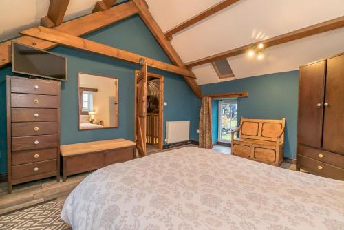 a bedroom with blue walls and a large bed at Cefn-Isaf in Llanbedr