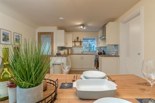 a kitchen with a wooden table with wine glasses at Pwerdy in Betws-y-coed