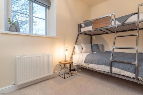 a bedroom with a bunk bed and a window at Pwerdy in Betws-y-coed