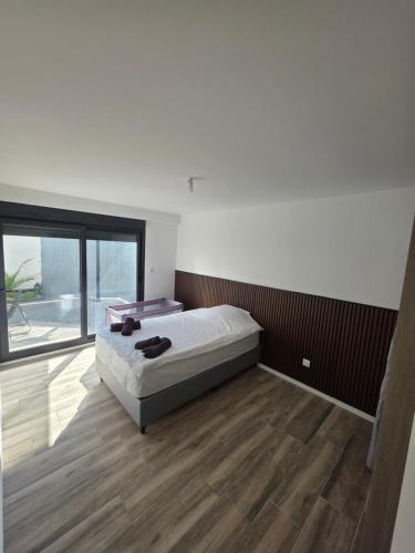 a bedroom with a bed and a large window at Comfort and tranquility, like at home in Saint-Barthélemy-dʼAnjou