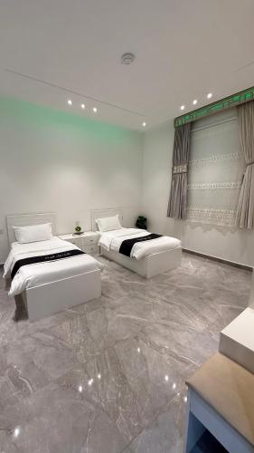 two beds in a room with marble floors at شاليه ليالي الفندقيه in Taif