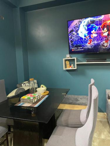 ein Esszimmer mit einem Tisch und einem TV an der Wand in der Unterkunft Ortiz house in Huaraz