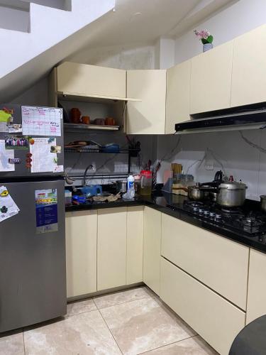 eine Küche mit weißen Schränken und einem Kühlschrank in der Unterkunft Ortiz house in Huaraz