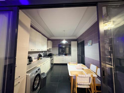 a kitchen with a table and a washing machine at Haut Standing Appartement meublé Mamelles in Dakar