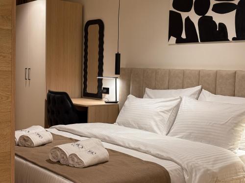 a bedroom with a bed with two towels on it at Soho Suites Skopje City Centre - Luxury Apartments in Skopje