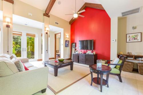 a living room with a red wall at Pomegranate Cottage in West Bay