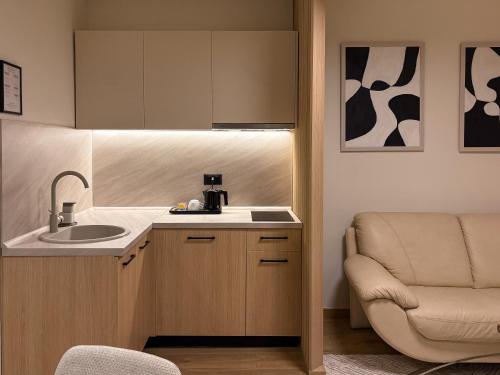 a small kitchen with a sink and a chair at Soho Suites Skopje City Centre - Luxury Apartments in Skopje