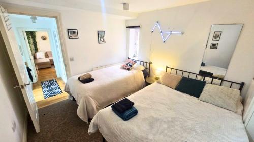 a bedroom with two beds and a mirror at Urban Oasis Stylish Boho Flat in Bristol in Bristol