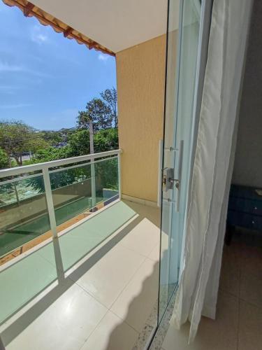 a room with a balcony with a glass door at casa amplia y luminosa en porto da barra in Búzios