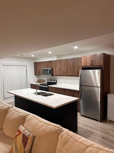a kitchen with a stainless steel refrigerator and a couch at Entire 3 bedroom townhouse in Cambridge