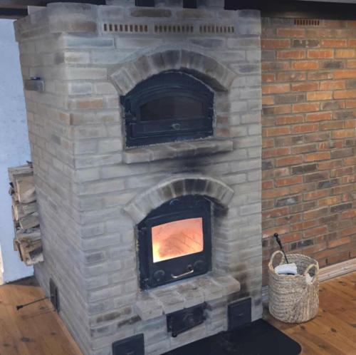 a brick fireplace with a tv on top of it at Holiday In A Cozy Farmhouse With Horses in Bøvlingbjerg