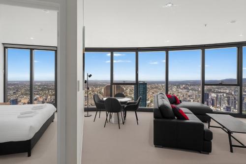 Un dormitorio con una cama y una mesa y sillas. en Panoramic Views Apartment & High-Rise Pool and Gym, en Brisbane