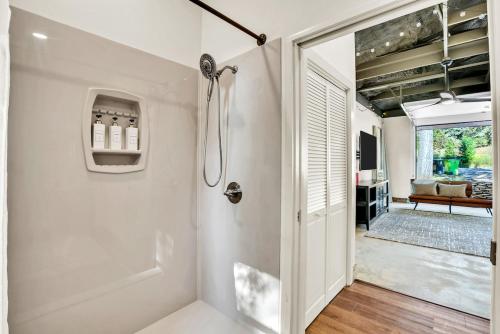 a white bathroom with a shower and a glass door at Flint Palestine Lakefront Retreat Firepit BBQ in Flint