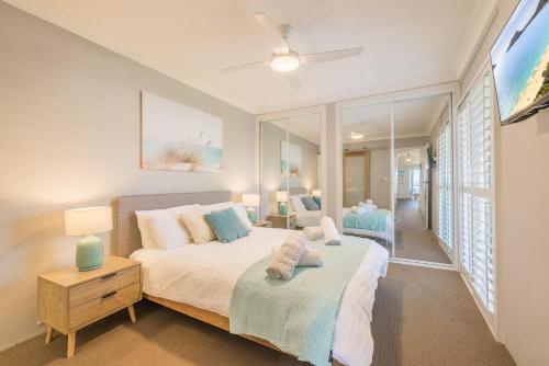 a bedroom with a bed and a table and a tv at Sunset Towers 11, 25 Donald St - stunning water views, air con, Wi-Fi and Linen provided in Nelson Bay