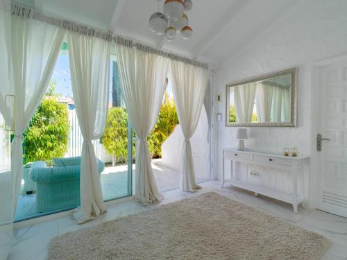 a living room with a large window and a mirror at FaroQuilla Suites Pasito Blanco in Pasito Blanco