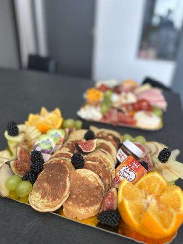 two plates of food with fruit on a table at Appartement de luxe avec jacuzzi dans le centre de Macon in Mâcon