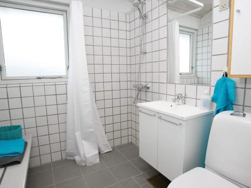 a bathroom with a sink and a toilet and a mirror at Vigsø Holiday Center- Type 7 in Hanstholm