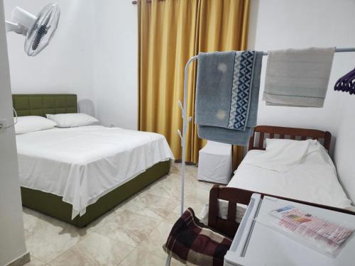 a bedroom with a bed and a chair and a fan at Bujtina Ismet Gjeli 
