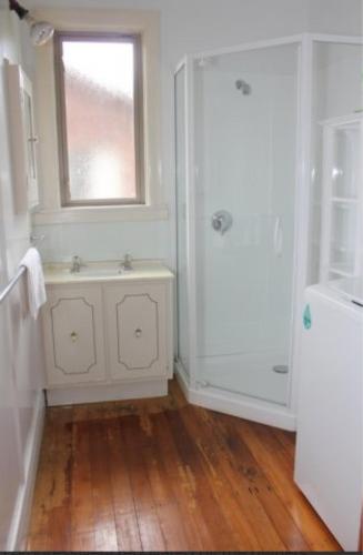 a bathroom with a shower and a sink and a window at 29 Jollies Pass Road in Hanmer Springs