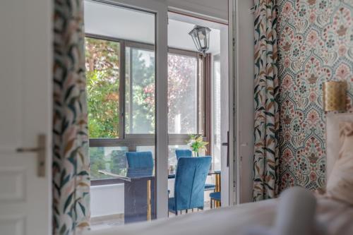 a room with a window with two chairs and a table at Sous les Étoiles! in Saint-Ouen