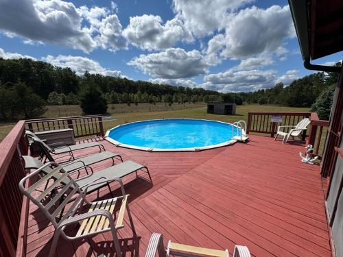 a deck with chairs and a swimming pool on a house at Revilo Moose Ridge Mauston in Mauston