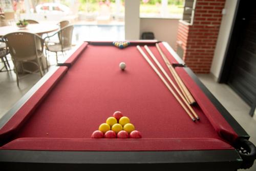a pool table with cue balls and chopsticks on it at Apto com 2 Suites, Piscina e Jogos a 100m da praia in São Bento