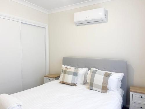 a bedroom with a white bed with pillows at Eliza's Escape 1 Wagga CBD in Wagga Wagga