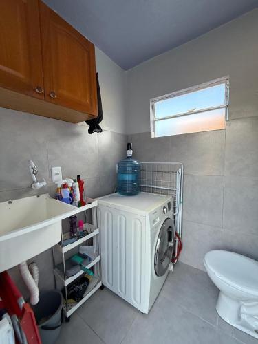 a washing machine in a bathroom with a sink at Casa Nova com 3 quartos in São Gabriel