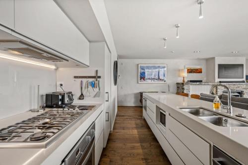 a kitchen with white counters and a stove top oven at Luxury Lakeview on Ardmore with Sauna in Wanaka