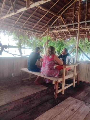 a group of people sitting at a picnic table at Naviza Homestay in Kepulauan Fam