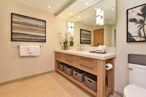a bathroom with a sink and a mirror at Whaler 859 BeachFront Luxury Condo w Ocean Views in Lahaina