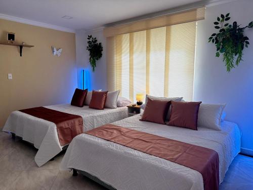 two beds in a room with blue lights at Kaobba Hostal in Medellín