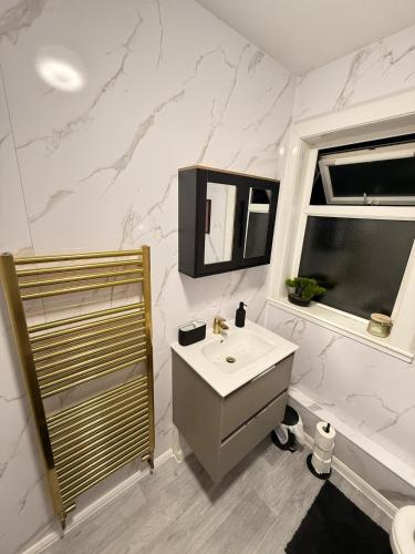 a bathroom with a sink and a mirror and a shower at The Royal Hue 4bed house close to city centre in CBG
