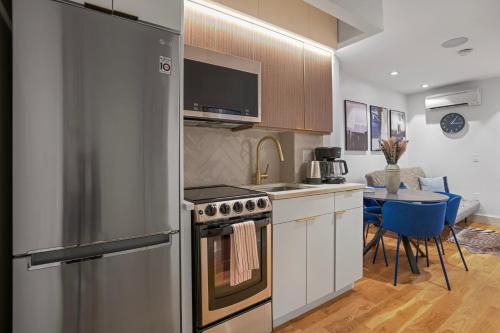 una cucina con frigorifero in acciaio inox e tavolo di Comfortable 2BD Unit in Manhattan a New York