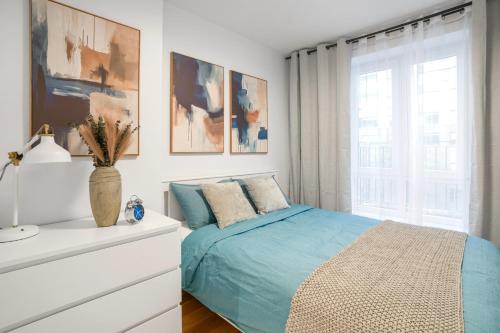 ニューヨークにあるComfortable 2BD Unit in Manhattanの青いベッドと窓のある寝室