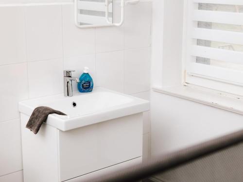 een witte badkamer met een wastafel en een raam bij Hubertus I in Bad Pyrmont