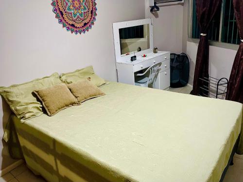a bedroom with a bed with a desk and a television at Quartos Privativos Com Cama de Casal in Vitória