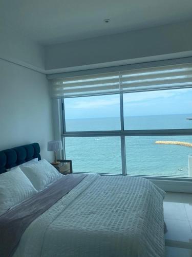 a bedroom with a large window with a view of the ocean at Luxury Ocean View - Bocagrande in Cartagena de Indias