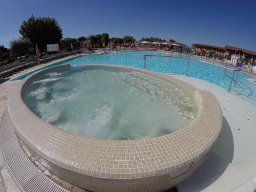a large swimming pool with a hot tub at The Garda Village in Sirmione