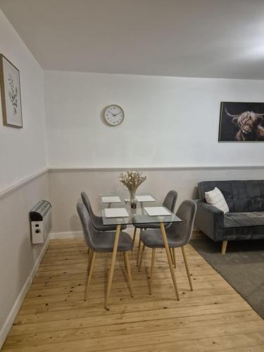 a dining room with a table and chairs and a couch at Modern apartment in Glasgow West End, free parking in Scotstoun West Station