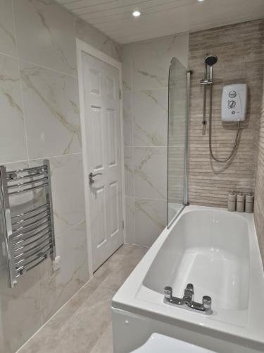 a white bathroom with a sink and a shower at Modern apartment in Glasgow West End, free parking in Scotstoun West Station