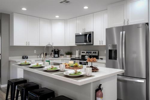 a kitchen with white cabinets and a stainless steel refrigerator at Red Mountain Retreat in Leisure World