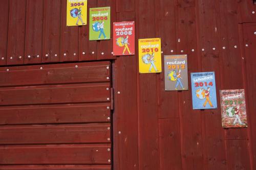 a wall with books on it with posters on it at Auberge du Thiollet in Montromant