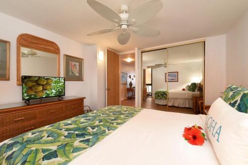a bedroom with a large bed and a mirror at Kaleialoha 309 · KA 309 Oceanfront Condo AC Ocean Views Heated P in Kahana