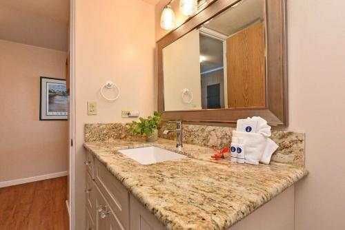 a bathroom counter with a sink and a mirror at Kaleialoha 309 · KA 309 Oceanfront Condo AC Ocean Views Heated P in Kahana