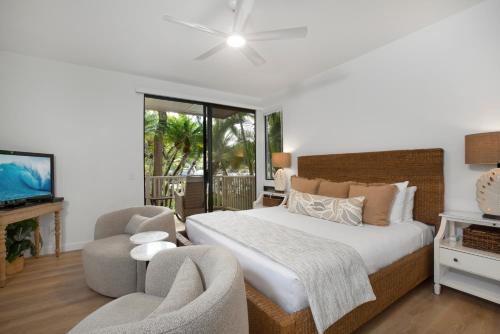a bedroom with a bed and a chair and a television at Wailea Grand Champions 95 in Wailea